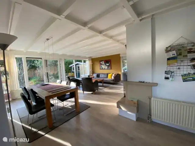 De ruime zit-eetkamer heeft kijkt uit op de tuin